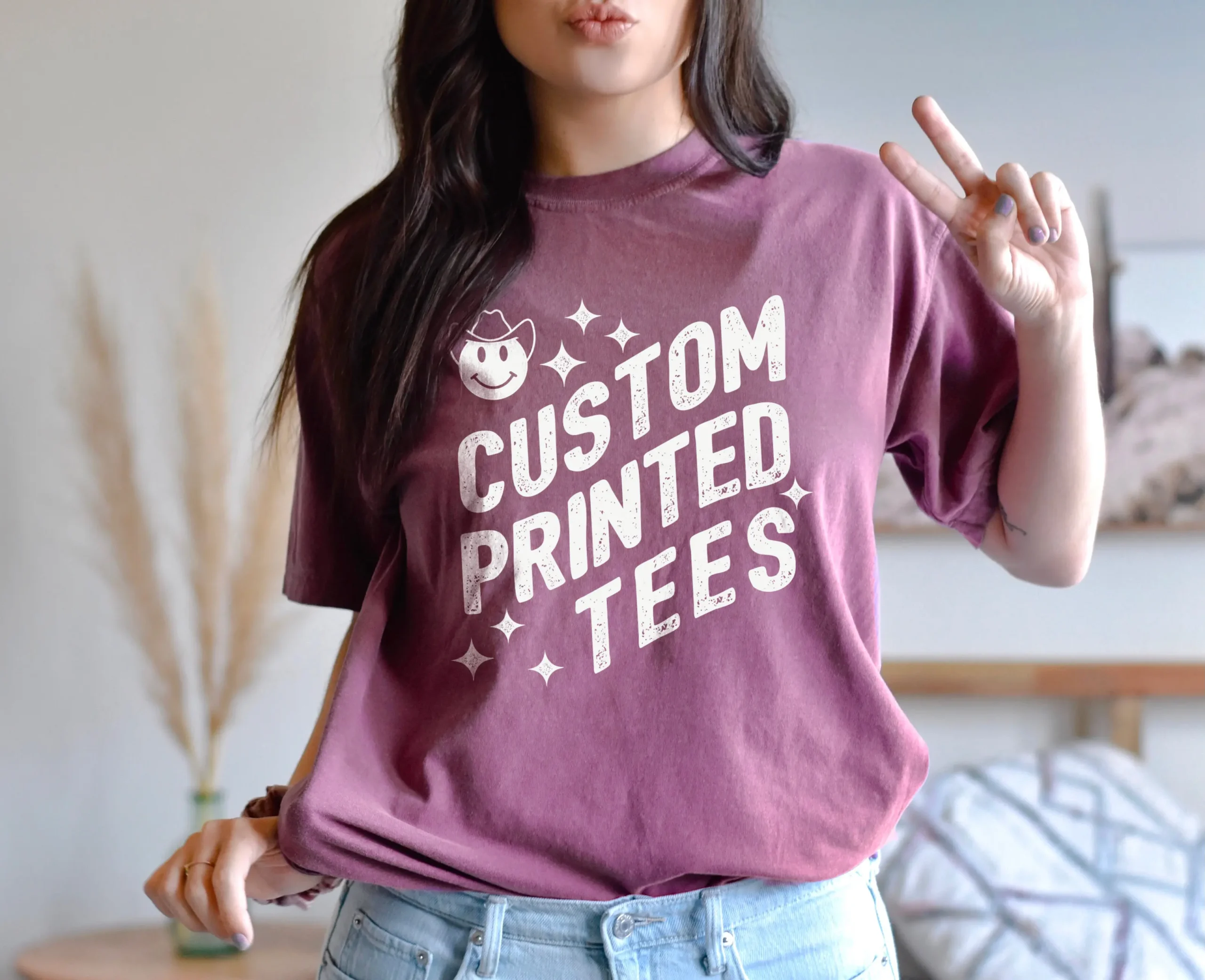 Woman wearing a t-shirt giving a peace sign.