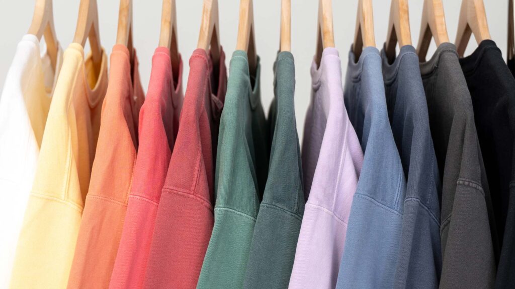 Colorful sweatshirts on hangers.